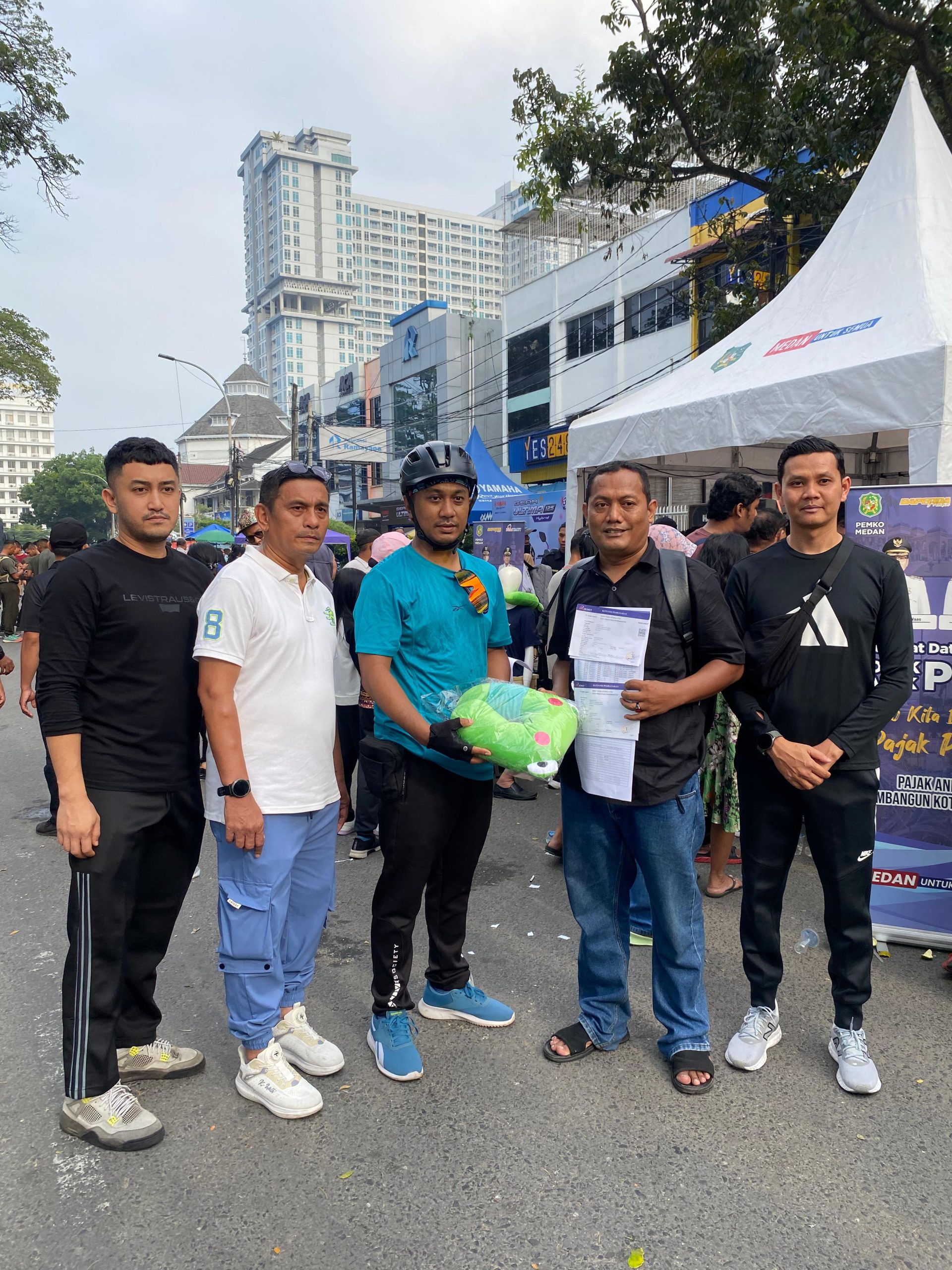 Foto Plt. Kepala Bapenda Kota Medan, T. Roby Chairi didampingi Kabid. BPHTB & PBB, Sutan Partahi memberikan hadiah kepada warga masyarakat yang membayar PBB di Pojok PBB saat CFD Berlangsung